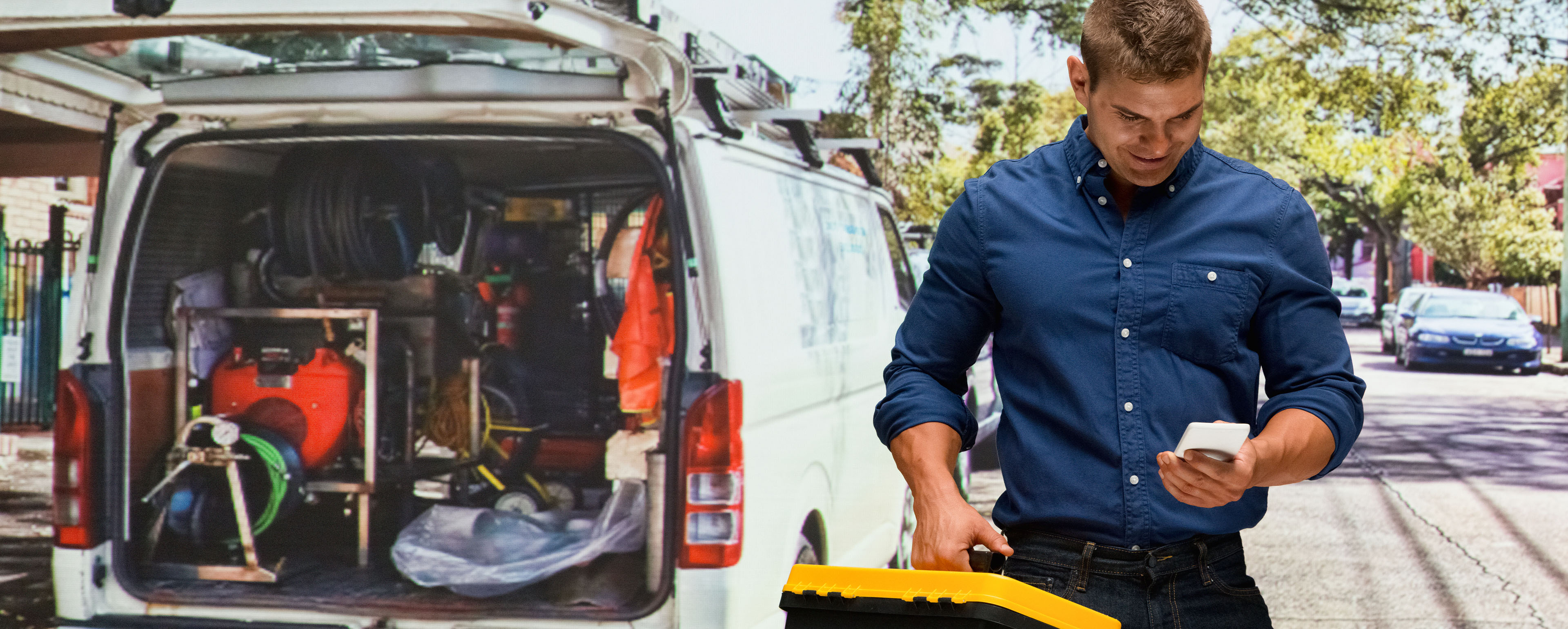 Handwerker mit Koffer vor Transporter