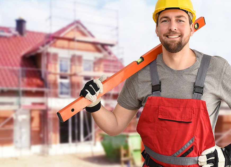 Zufriedener Handwerker mit Wasserwaage auf Baustelle